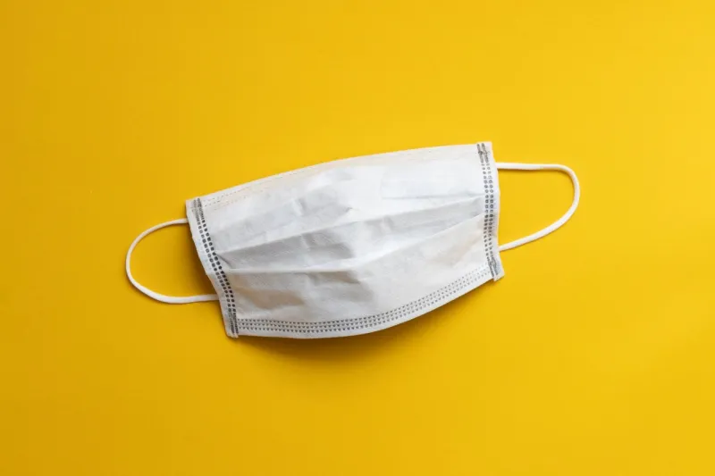 medical disposable face mask on yellow background, protection and prevention for covid-19 or wuhan novel coronavirus spread