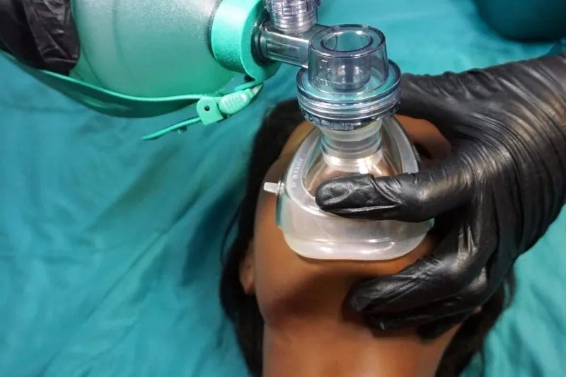 medical stuff in black gloves performing artificial ventilation using bag valve mask (ambu bag) on a simulation mannequin dummy during medical training to control of the airway general anesthesia