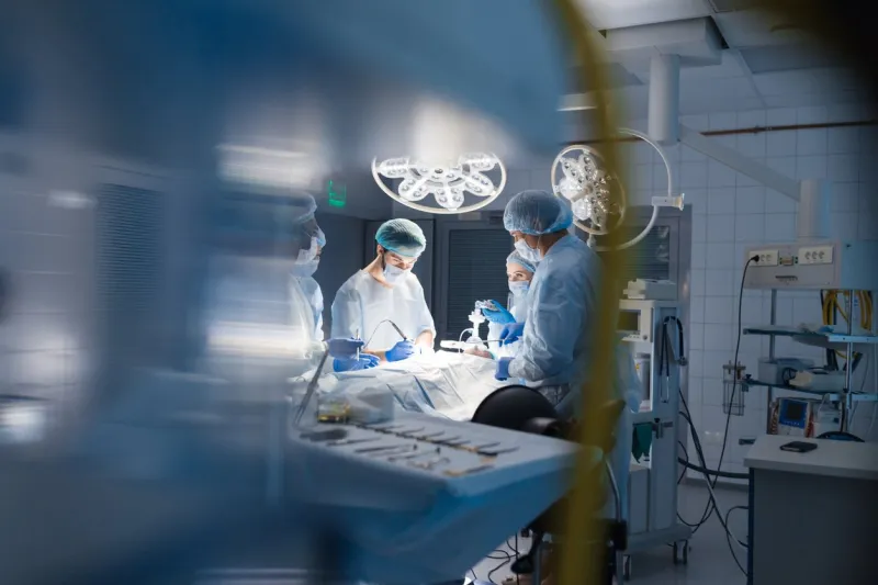 blurred shot of group of professional surgeons at work in operating room emergency case, surgery, medical technology, health care cancer and disease treatment concept