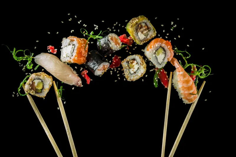 seamless pattern with sushi food abstract background flying sushi, sashimi and rolls isolated on the black background