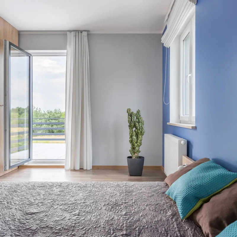 bright bedroom with large bed and open balcony doors