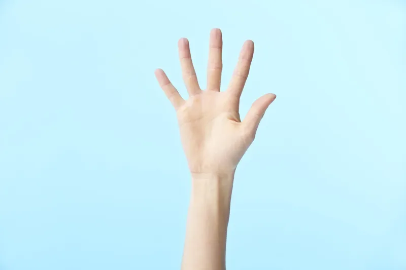 human hand showing number five, isolated on blue background