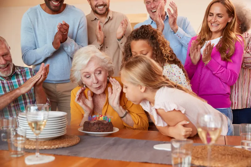 multi-generation family meet to celebrate grandmothers birthday at home together
