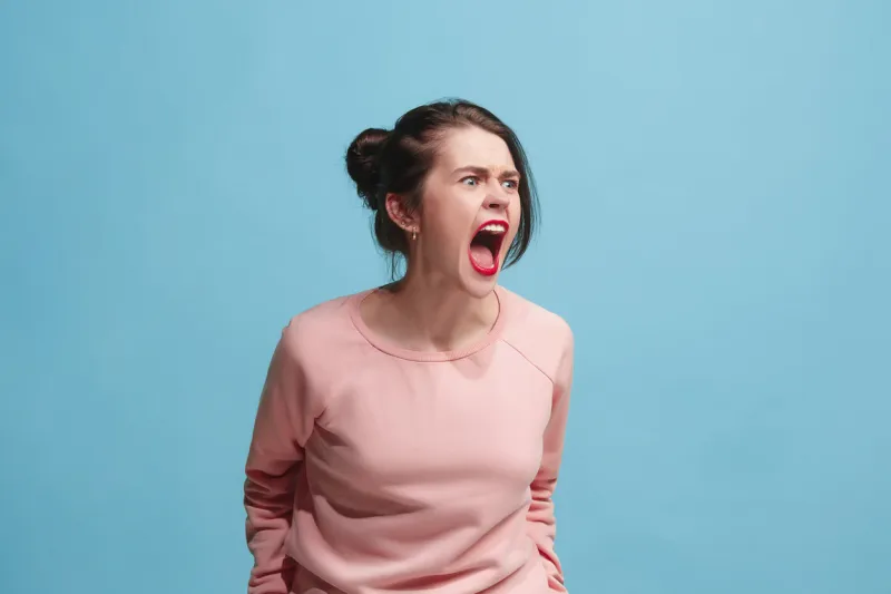 screaming, hate, rage crying emotional angry woman screaming on blue studio background emotional, young face female half-length portrait human emotions, facial expression concept trendy colors