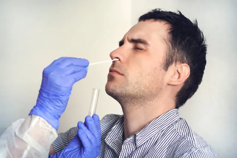 a doctor in a protective suit taking a nasal swab from a person to test for possible coronavirus infection nasal mucus testing for viral infections