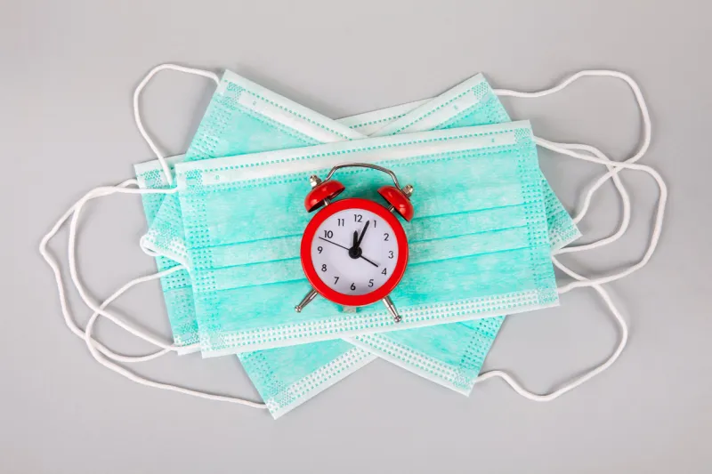 disposable mask against coronavirus 2019-ncov droplet infection and an antibiotic syringe it lies on a gray background