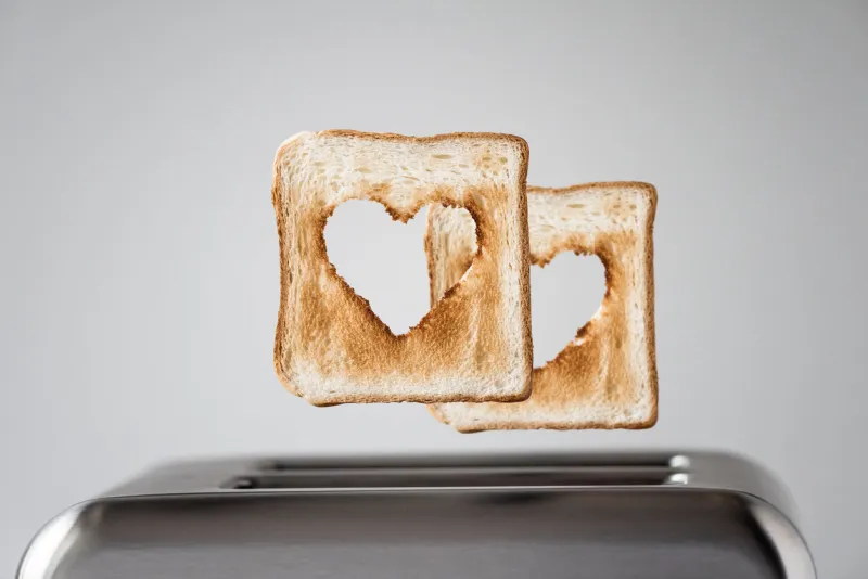two heart shaped on roasted toasted bread in a toaster breakfast preparation on valentine's day symbol sign of love concept