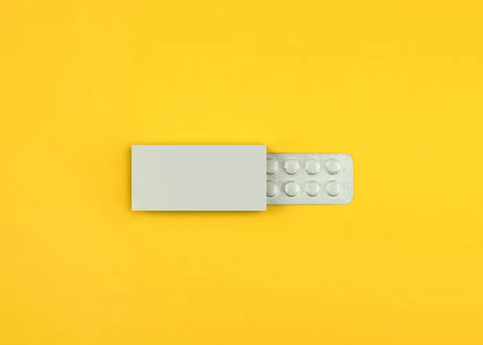 pills in a box on a yellow background
