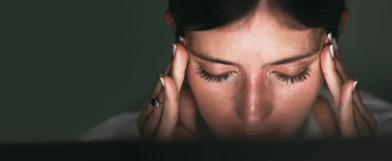 closeup shot of a young businesswoman looking stressed out while working in an office at night