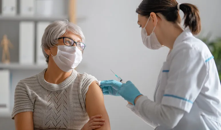 doctor giving a senior woman a vaccination virus protection covid-2019