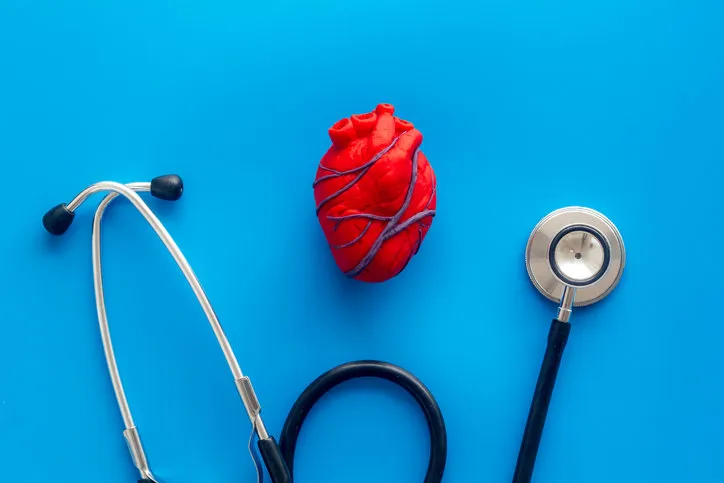 heart and treatment heart near pills tonometer, treatment on blue background top view