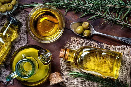 top view of olives and olive oil bottles on table in a rustic kitchen