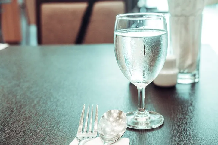 cold water in glass on dinner table food at restaurant concept