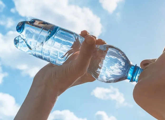 woman drinking water after her workout