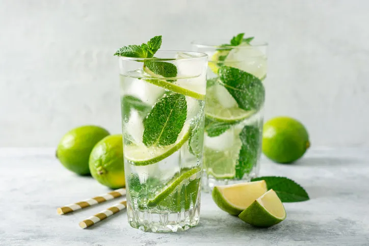 fresh mojito cocktail with lime and mint in glass on concrete background cold refreshing drink selective focus
