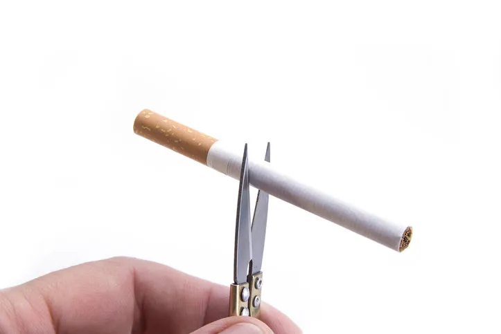 detail of cigarette cut with the hand scissors stop smoking concept