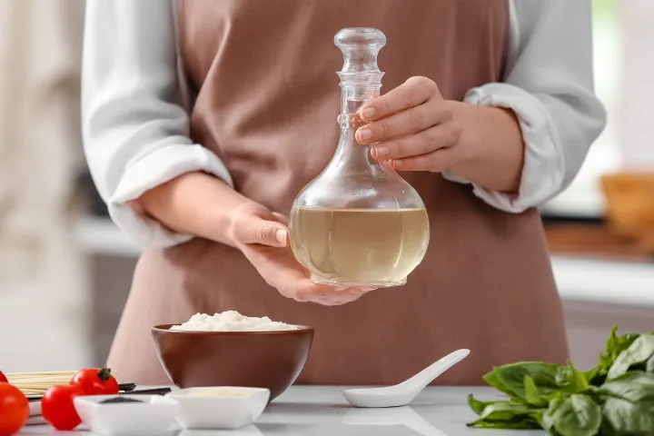 woman with bottle of rice vinegar in kitchen