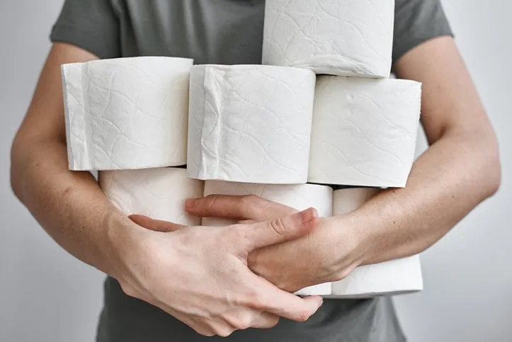 people are stocking up toilet paper for home quarantine from crownavirus woman holds many rolls of toilet paper