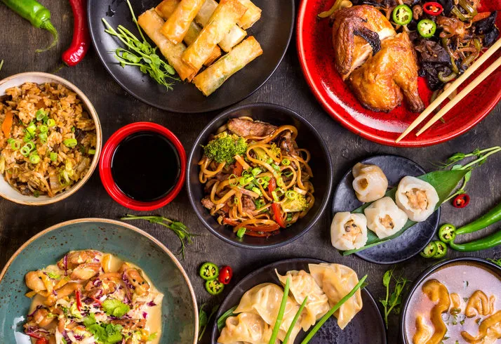 assorted chinese food set chinese noodles, fried rice, dumplings, peking duck, dim sum, spring rolls famous chinese cuisine dishes on table top view chinese restaurant concept asian style banquet
