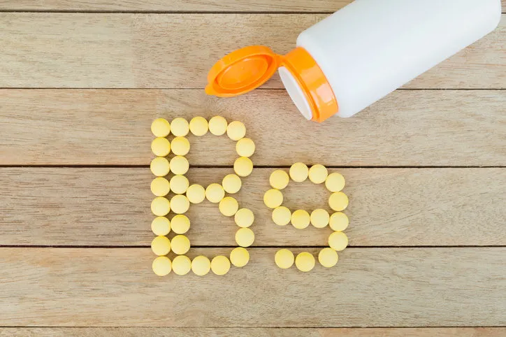 yellow pills forming shape to b9 alphabet on wood background