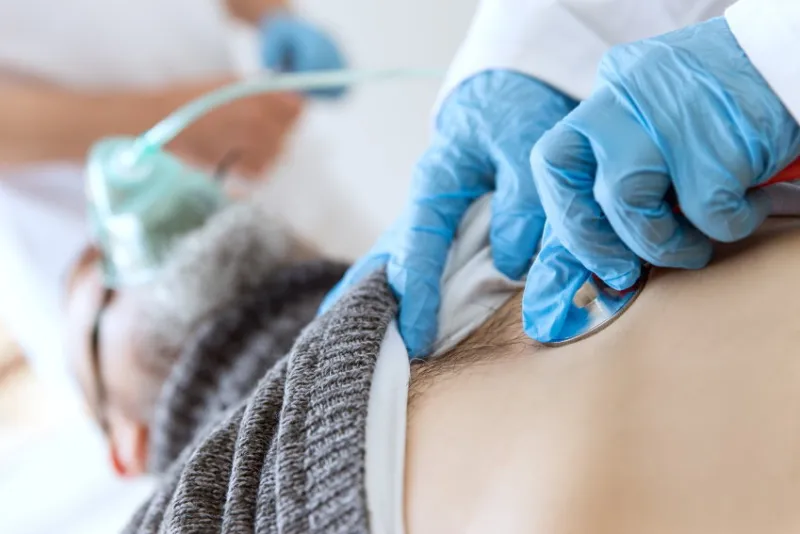 patient in der intensivstation, beatmung und untersuchung mit dem stethoskop