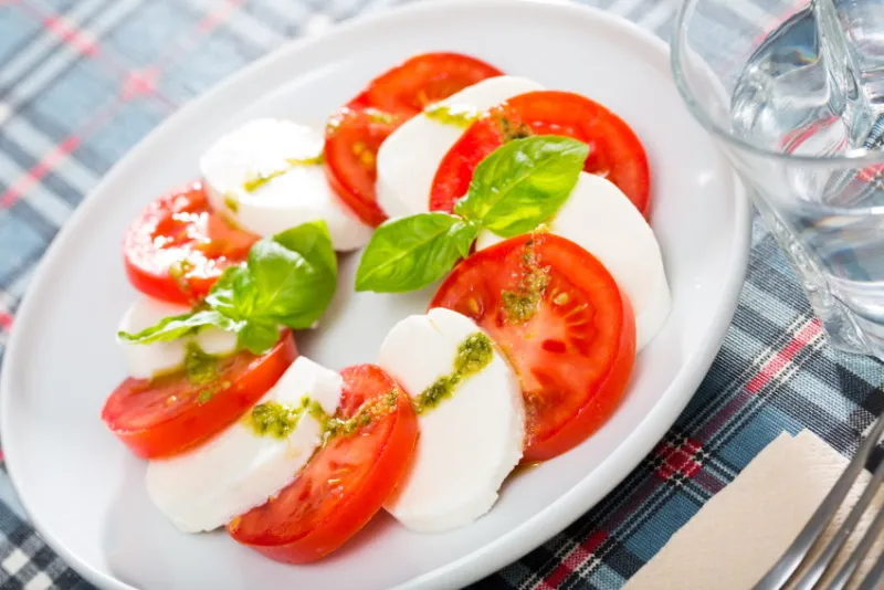 salad caprese with tomatoes, mozzarella cheese and herbs, dish of italian cuisine