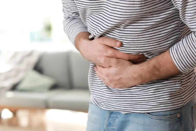 young man suffering from stomachache at home