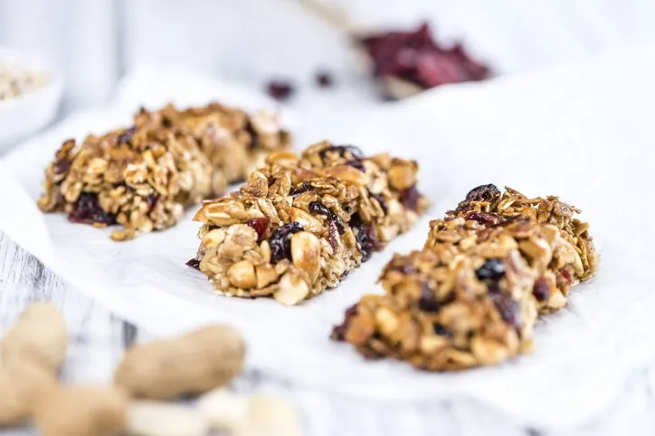 homemade granola bars with peanuts and cranberries (selective focus) as detailed close-up shot (homemade granola bars with peanuts and cranberries