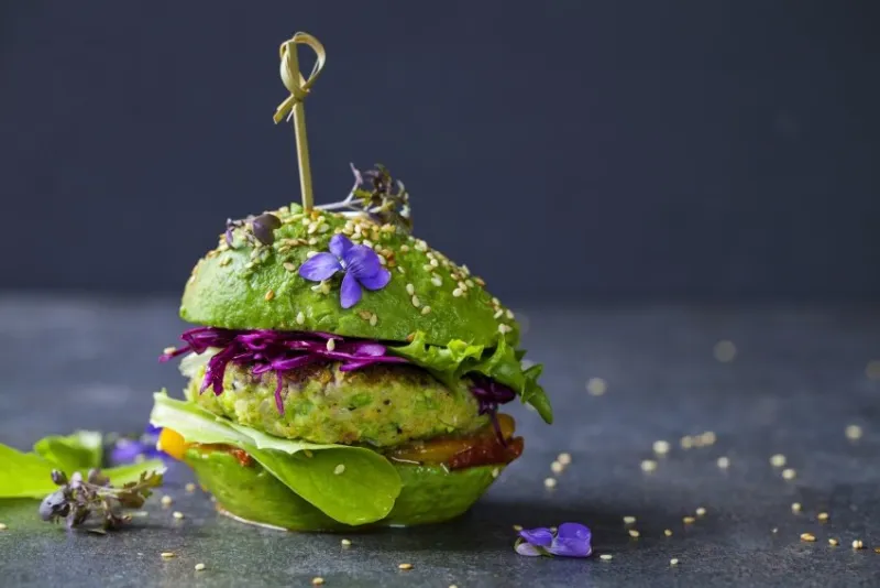 avocado sandwich with green vegan burger, roast yellow pepper and pickled red cabbage