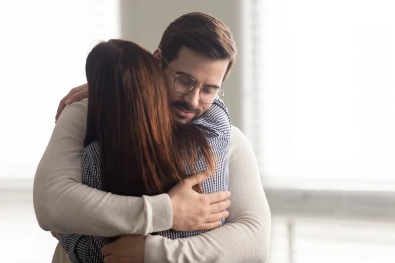 handsome man embracing woman calms in difficult moment husband hugging wife relieves stress from work or health friends and couple relationship concept
