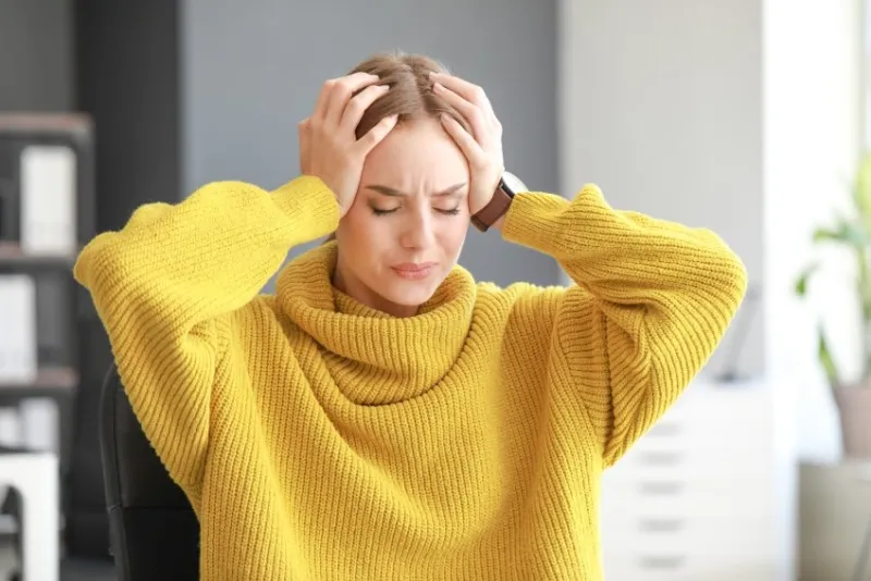 young woman suffering from headache at home