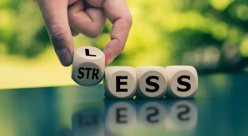 having less stress or being stress-less hand turns a cube and changes the word stress to less