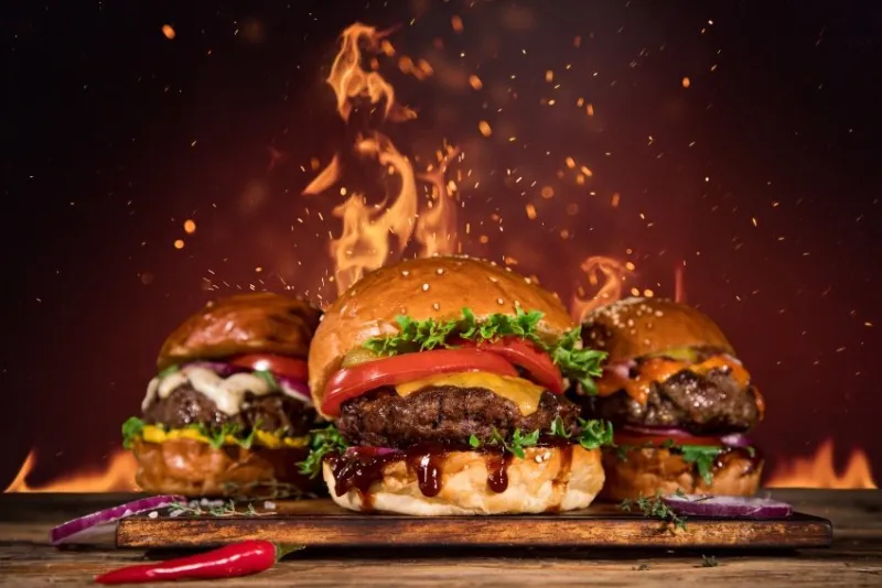close-up of home made tasty burger with french fries and fire flames