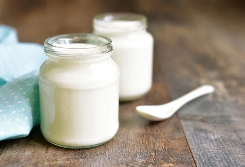 homemade yogurt in a glass jar on a wooden table