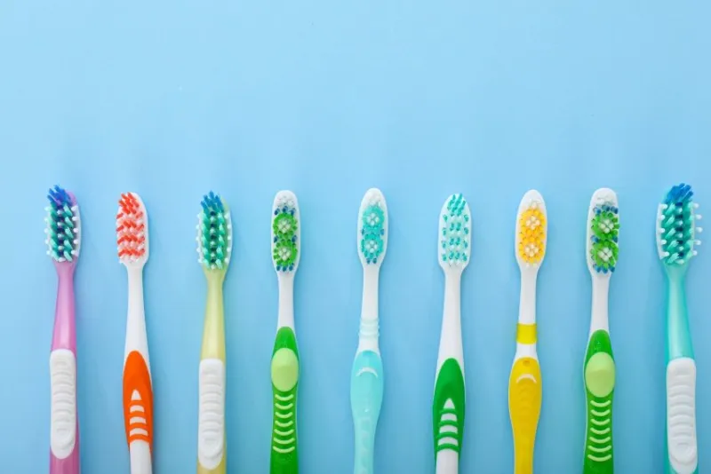 many tooth brushes on color background