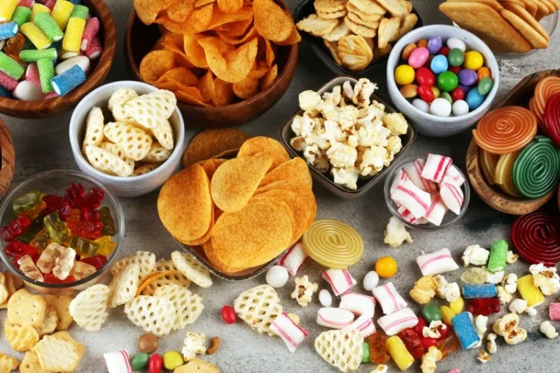 salty snacks pretzels, chips, crackers and candy sweets unhealthy products food bad for figure, skin, heart and teeth assortment of fast carbohydrates food