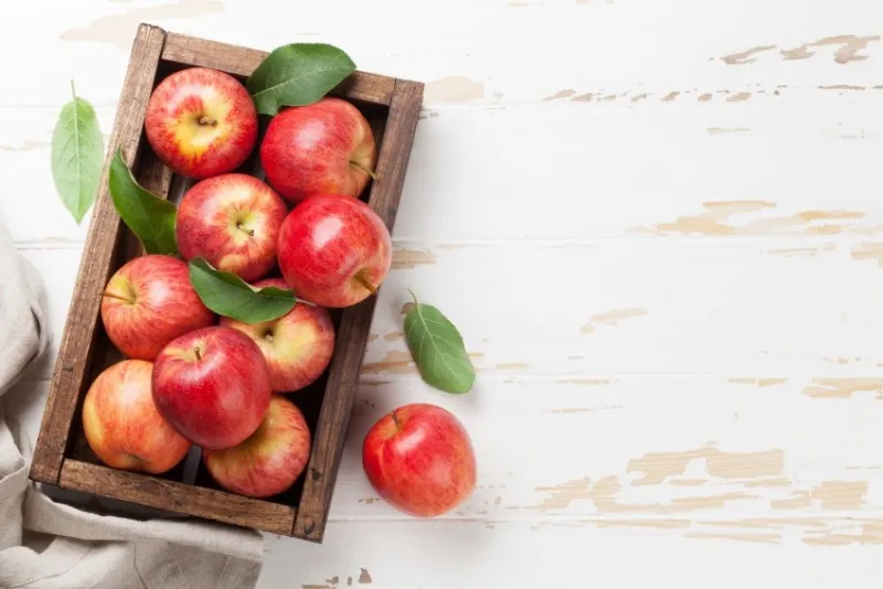 ripe red apples on wooden table top view with space for your text