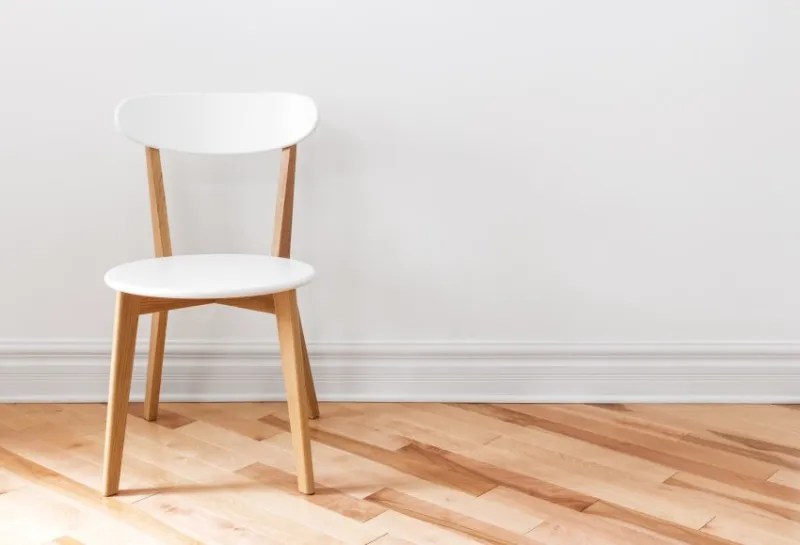 elegant white chair in an empty room with wooden floor
