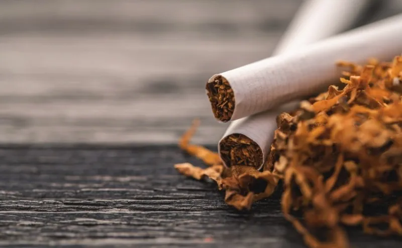 cigarettes and tobacco on a black wooden background