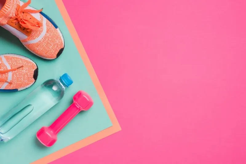 flat lay with sport equipment on pink background