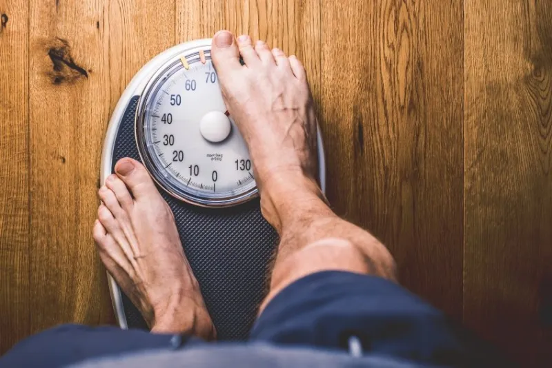 personen waage auf einem holzboden