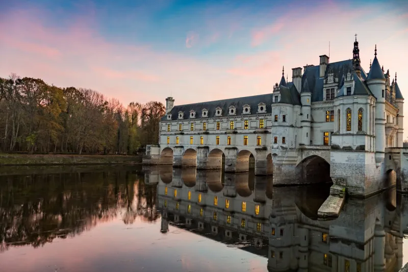 chenonceaux,france - november 10, 2015  chateau de chenonceau loire valley france at sunset with reflection of building and sky in the river cher