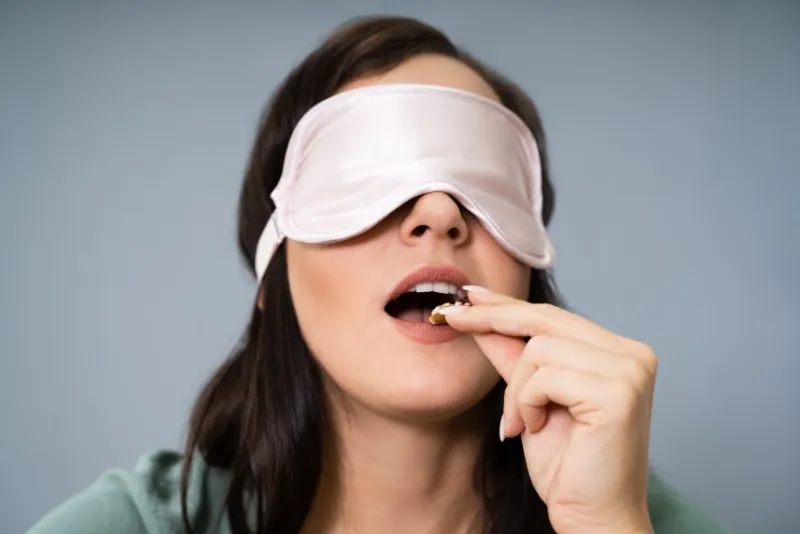 portrait of blindfolded young woman testing food