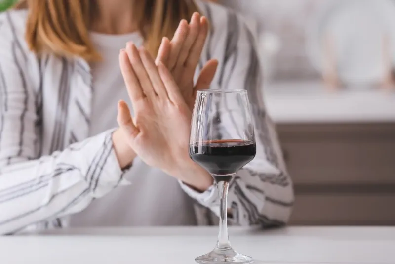 woman refusing to drink wine at home concept of alcoholism