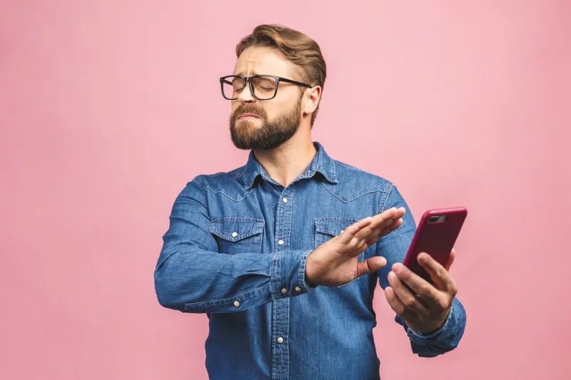 young handsome business man talking on the phone over pink isolated background with open hand doing stop sign with serious and confident expression, defense gesture
