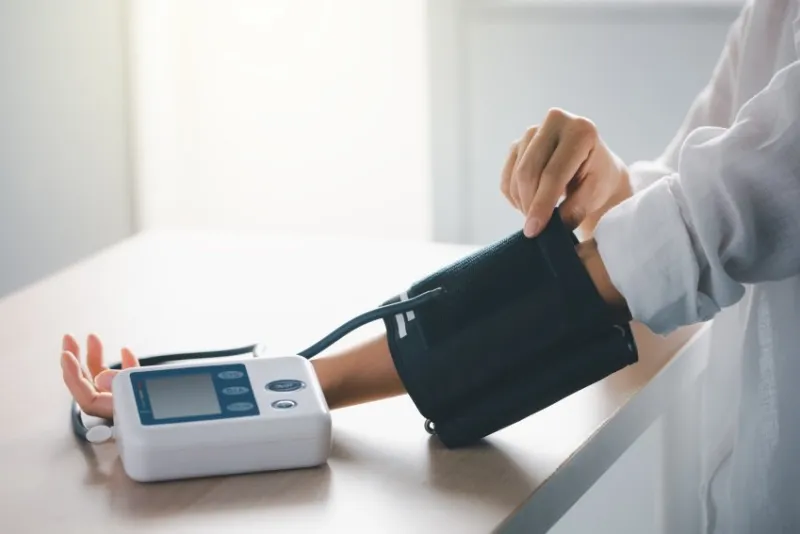 self blood pressure and heart rate measurement with blood pressure monitor machine, healthcare and medical concept