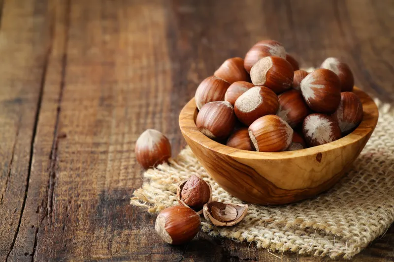 hazelnuts in a wooden bowl on rustic background