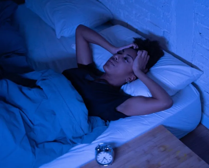 young beautiful afro american woman at home lying in bed late at night trying to sleep suffering insomnia sleeping disorder or scared on nightmares looking stressed and worried mental health concept