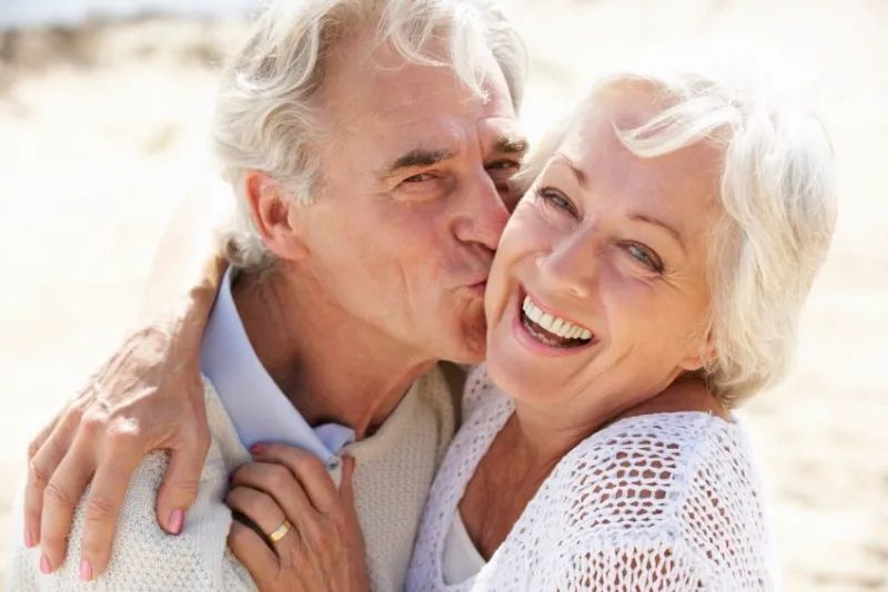 senior couple walking along beach together