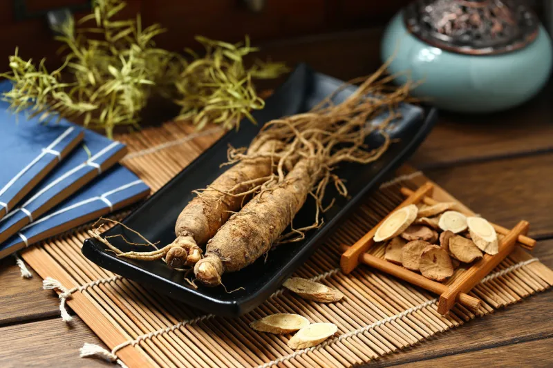 ginseng in black plate on wooden table